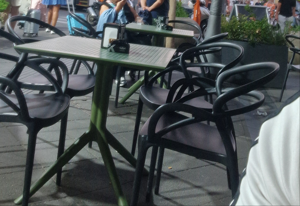 Set di quattro sedie con braccioli realizzate in polipropilene di colore nero il tavolo escluso